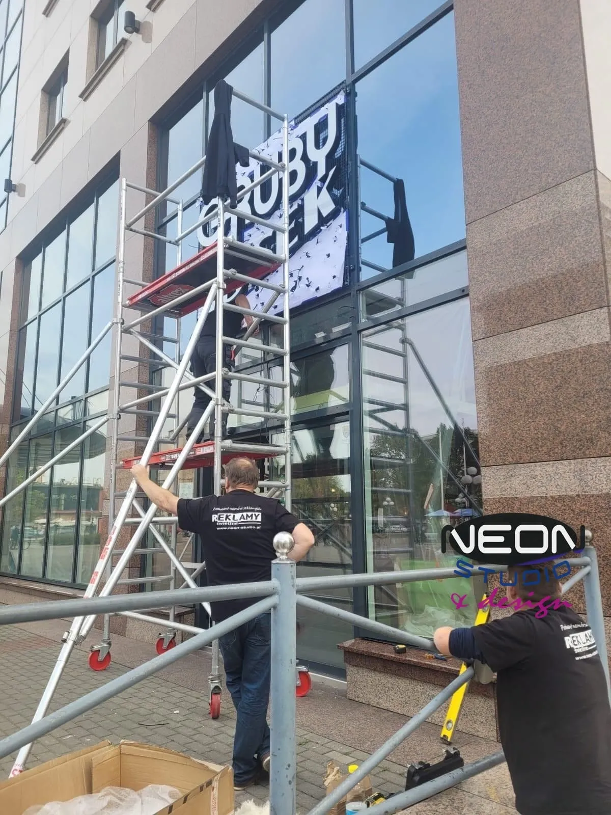 Installing signage from scaffolding — work at height requires certification